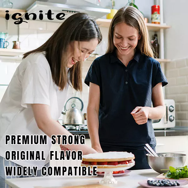 The image shows two people in a kitchen, one in a white shirt and the other in a black polo shirt, smiling and working together on a cake that sits on a stand. The setting appears casual and homely, with various cooking utensils and ingredients visible. Overlaid on the image are words that seem to be advertising qualities: "ignite," "premium," "strong," "original flavor," and "widely compatible." These words suggest the promotion of a product, likely related to food or cooking, that prides itself on quality and versatility.