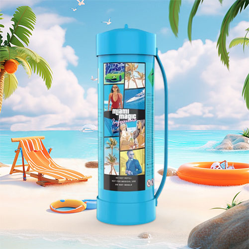 The image presents a cream charger canister with a "Miami Magic" theme, featuring images that evoke the lively atmosphere of Miami, including palm trees, sun, and stylish people. The canister is turquoise, complementing the beach setting in which it is placed. The canister has a handle, indicating its large size and perhaps enhanced functionality. The beach scene is complete with a sun chair, a beach ball, a sun hat, and an orange life ring, set against a backdrop of a sandy shore, palm trees, and a clear blue sky with a calm sea. The design of the canister, coupled with the idyllic beach setting, suggests a blend of festive culinary experiences with the laid-back, sunny vibes of Miami life.